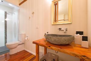 新普利茅斯霍斯金别墅的一间带石质水槽和卫生间的浴室