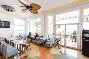 迈阿密海滩Majestic Hotel South Beach, Trademark Collection by Wyndham的餐厅的饭厅,有坐在餐桌旁的人
