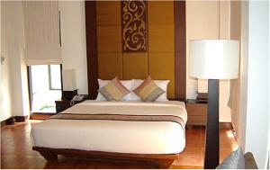 象岛Chang Buri Resort & Spa的一间卧室配有一张大床和一盏灯