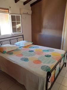 拜马欧chez jojo的一间卧室配有一张带彩色毯子的床