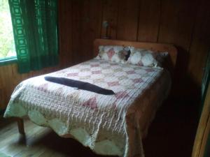 圣赫拉多德多塔Las Cataratas Lodge的一张带毯子的床,上面有两根棍子