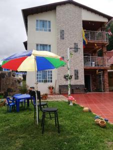蒙圭Portal de la Cascada - Mongui的房子院子里的一把色彩缤纷的雨伞