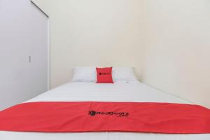 雅加达RedDoorz @ Tanjung Duren的白色客房内的红色和白色床铺