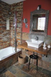 Valdefuentes巴尔德丰特斯奥利瓦尔乡村酒店的一间带水槽、浴缸和镜子的浴室