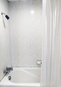 YasothonJP Emerald Hotel的浴室内设有带浴帘的白色浴缸