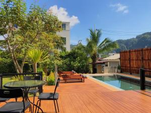 奥南海滩Siya Private Pool Villa Ao Nang的池畔甲板配有桌椅
