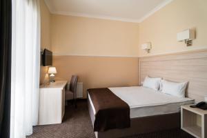 敖德萨Potemkinn Hotel的配有一张床和一张书桌的酒店客房