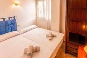 贝尼塔切利Villas Guzman - Apartamento Murillo的一间卧室配有一张床,上面有两条毛巾