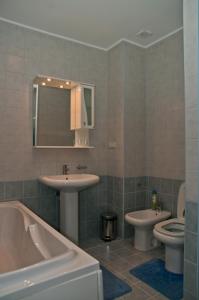 鲍里斯皮尔利吉纳酒店的一间带两个盥洗盆、浴缸和卫生间的浴室