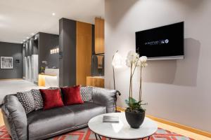 波尔图波尔图中心欧洲之星酒店的客厅配有沙发和墙上的电视
