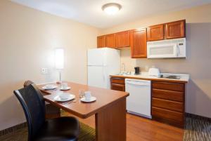 拉皮德城GrandStay Residential Suites Rapid City的一间带桌子和冰箱的小厨房