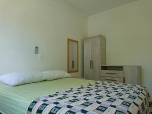 邦比尼亚斯Residencial Maria Idia的一间卧室配有一张床和一个橱柜
