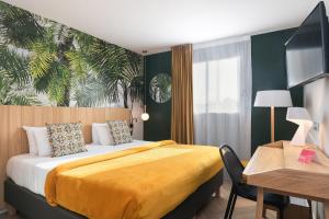 图卢兹Hôtel Innes by HappyCulture的酒店客房配有一张床、一张桌子和一张桌子。