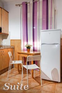 贝尼多姆Irati的厨房配有桌子、冰箱和椅子