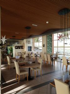MalvilliersHotel du Val的餐厅设有木制天花板和桌椅