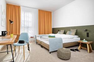 卢布林Arche Hotel Lublin的卧室配有1张床、1张桌子和1把椅子