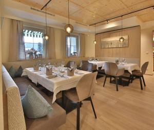 瑟弗浩斯Hotel Castel - pure Lebensfreude的餐厅设有白色的桌椅和窗户。