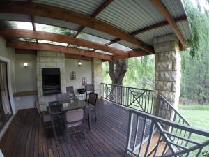 克拉伦斯Willow Creek Villas的户外甲板设有壁炉和桌椅