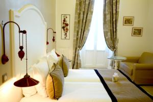 圣马克西姆邦瑞珀斯皇家酒店的一间卧室配有一张床、一张沙发和一个窗口