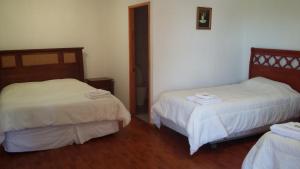 孔斯蒂图西翁Hotel Nogal的一间设有两张带白色床单的床的房间