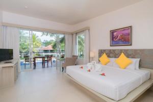 蔻立The Briza Beach Resort, Khao Lak SHA Extra Plus的卧室配有一张白色大床和电视。