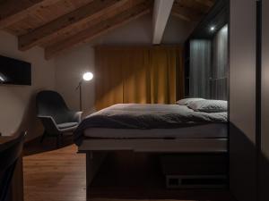 采尔马特Malteserhaus Zermatt的一间卧室配有一张床和一把椅子
