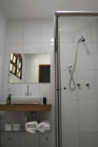Praia do BananalPousada Três Coqueiros的浴室配有盥洗盆和带镜子的淋浴