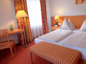 菲拉赫Motel55 - nettes Hotel mit Self Check-In in Villach, Warmbad的酒店客房配有一张床铺、一张桌子和一张书桌。