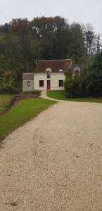 SeigyLa Graine de Beurre proche zoo de Beauval的土路上的白色房子,有红色的门