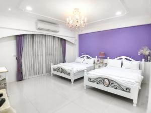 东港乐忆时光的卧室设有两张床铺和紫色墙壁