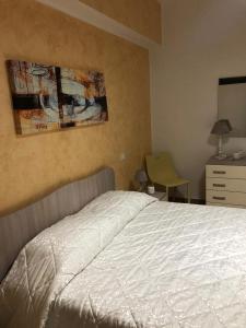 利扎诺House Le Fontanelle的卧室配有白色的床和梳妆台。