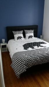 拉弗雷切Appartement Taïko的卧室配有带枕头的黑白床。
