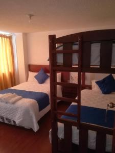 里奥班巴Hostal Alborada Riobamba的一间卧室设有两张双层床和梯子