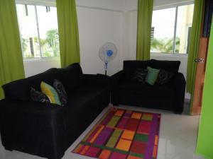 博卡奇卡热门公寓酒店的客厅配有两张黑色沙发和地毯。