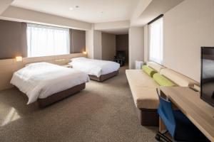 高松JR Clement Inn Takamatsu的酒店客房设有两张床和一台平面电视。