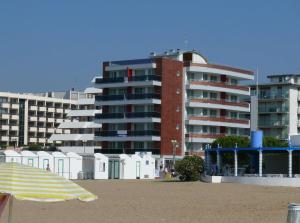 比比翁Residence Panorama Apart Hotel的海滩上的一座建筑,海滩上配有遮阳伞