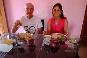菩提伽耶苏马旅馆的坐在餐桌上吃盘子的男人和女人