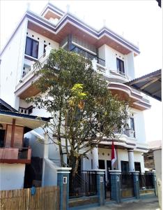 兰特包Toraja Lodge Hotel的前面有一棵树的白色房子
