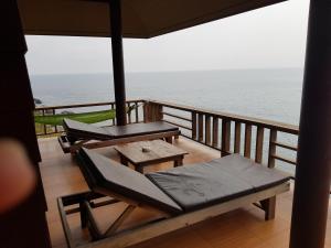 涛岛奥洛伊克大山度假村的阳台设有两张长椅和一张桌子,享有海景。