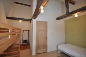 上富良野町上富良野旅馆的客房设有一张床和木梁楼梯