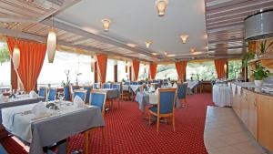 布尔雅格斯泰格酒店的餐厅设有白色的桌子和蓝色的椅子