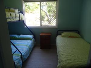 弗雷泽岛Elouera Units的一间卧室设有两张双层床和一扇窗户。