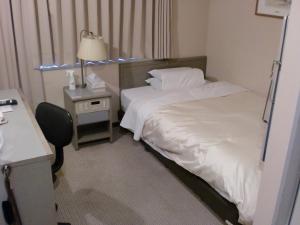 津山市津山中央饭店附楼的酒店客房配有两张床和一张带台灯的书桌