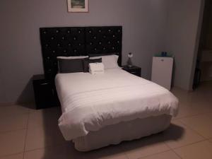 鲸湾港杰西玛住宿加早餐旅馆的卧室配有一张带白色床单和枕头的大床。