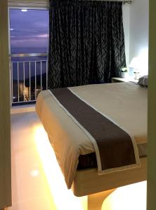大雅台Wind Residences Tower 4 18th Floor的一间卧室设有一张床和一个美景窗户。