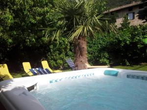 奥拉Garni Meinrad的一个带椅子的游泳池,并种植了棕榈树