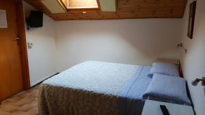 巴尔齐奥Foresteria Lombarda da Giovanna的一间卧室配有一张带蓝色棉被的床和窗户。