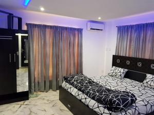 伊凯贾CG Apartments Metro的一间卧室设有一张床和一个大窗户