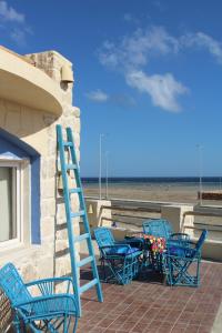 马萨阿拉姆Light House的一组蓝色的椅子,一张桌子和梯子