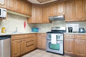 达利城Hostel Style Shared Room的厨房配有木制橱柜和炉灶烤箱。